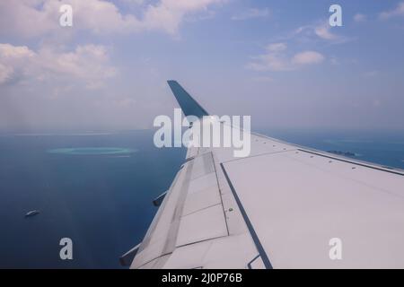 Vue aérienne depuis la fenêtre de l'avion jusqu'à l'île Male au milieu de l'océan Indien bleu, République des Maldives Banque D'Images