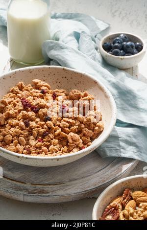 Sécher la granola dans un bol. Petit déjeuner, alimentation saine avec lait en bouteille, flocons d'avoine Banque D'Images