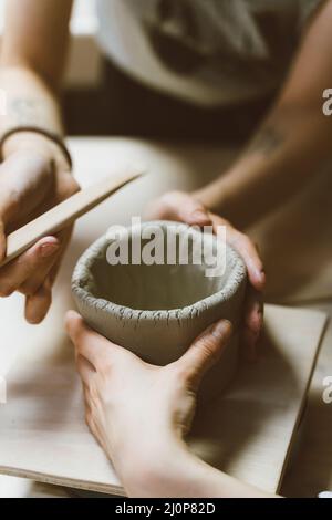 Femme faisant de la poterie céramique, quatre mains près, se concentrer sur des potiers, des palmiers avec poterie Banque D'Images