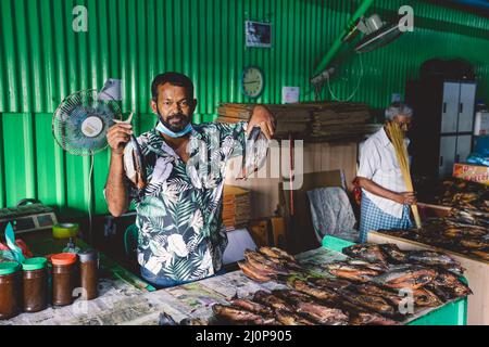 Vendeur local de poisson séché sur le marché central des Maldives de Male City Banque D'Images