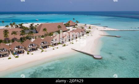 Vue aérienne sur les villas de luxe de l'eau au milieu de l'eau claire bleue au coeur de l'océan Indien, Maldives Banque D'Images