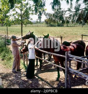 Vintage Italie 1970s, élégant couple d'âge moyen visite l'élevage de chevaux, la campagne romaine ranch, Lazio, Europe, Banque D'Images