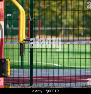 Ruban d'interdiction rouge et blanc sur la clôture du complexe sportif. Fermé pour visite, quarantaine, jour Banque D'Images