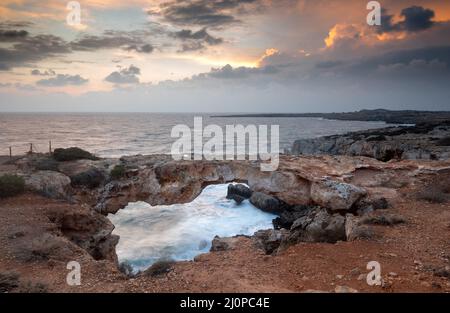 Paysage marin avec vagues venteuses pendant la tempête au coucher du soleil.Cap greko Chypre Banque D'Images