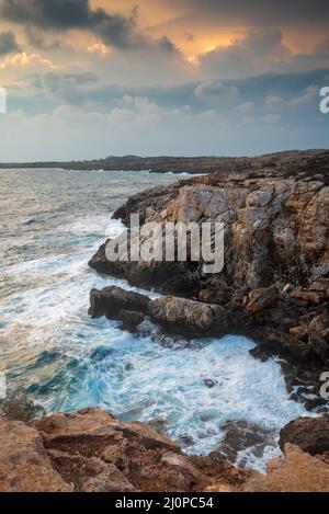 Paysage marin avec vagues venteuses pendant la tempête au coucher du soleil. Banque D'Images