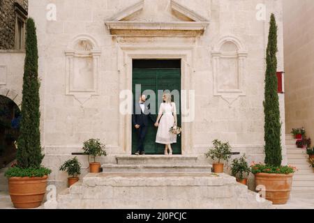 La mariée et le marié se tiennent sur le porche de l'église Saint-Marc l'Apôtre.Monténégro Banque D'Images