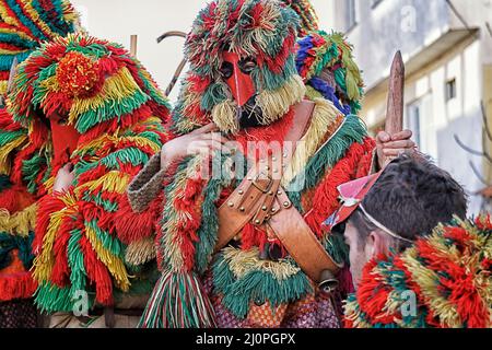 Les Caretos de Podence - groupe dans une charrette en bois dans la rue. Personnages traditionnels du carnaval portugais. Banque D'Images