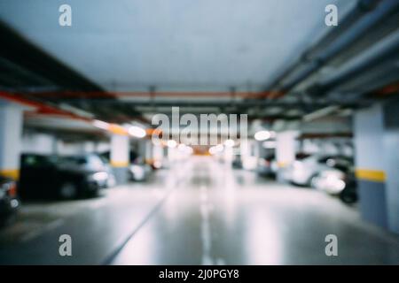 Les voitures sont garées dans un grand parking souterrain.Flou Banque D'Images