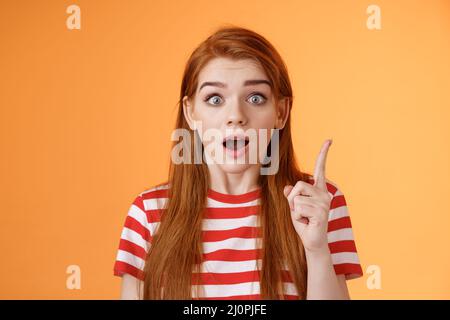 J'ai eu une idée. Excitée redhead femme partageant un plan intéressant, lever index doigt eureka geste, bouche ouverte dire pensée, se rappeler im Banque D'Images