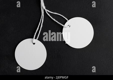 Deux maquettes d'étiquettes rondes blanches avec cordon blanc sur fond noir. Étiquettes de prix circulaires en papier blanc isolées, vente et concept du vendredi noir Banque D'Images