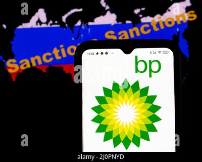 Dans cette illustration, le logo British Petroleum est affiché sur l'écran d'un smartphone avec un drapeau russe sous forme de carte du pays avec l'inscription sanctions en arrière-plan. (Photo par Igor Golovniov / SOPA Images/Sipa USA) Banque D'Images