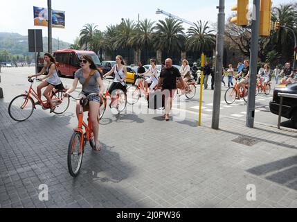 Cyclistes à un passage à niveau très fréquenté. Las Ramblas, Barcelone, Espagne. Banque D'Images