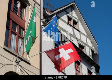 Saint-Gall, Suisse 9 mars 2022 drapeau suisse et drapeau européen avec drapeau du canton Saint-Gall sur la façade d'un vieux buil Banque D'Images