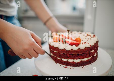 Le chef pâtissier prépare un délicieux gâteau au velours rouge. Cuisine et décoration du dessert Banque D'Images