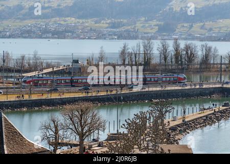 Rapperswil, Suisse le 27 février 2022 train traverse un pont au-dessus du lac de Zurich Banque D'Images