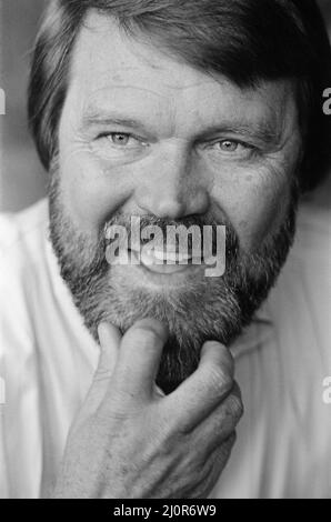 Glen Campbell à Londres. 19th avril 1984 Voir un autre cadre dans cet ensemble qui montre Glen, sa femme Kim et son fils Cal. Campbell a épousé Kimberly 'Kim' Woolen en 1982. Le couple s'est réuni à une date aveugle en 1981 quand Woolen était un radio City Music Hall 'Rockette'. Ensemble, ils ont trois enfants : CAL, Shannon et Ashley. Tous trois se sont joints à Campbell sur scène depuis 2010 dans le cadre de son groupe de tournée. Les hits de Campbell comprennent ses enregistrements de « Gentle on My Mind » de John Hartford, de « Gentle on My Mind » de Jimmy Webb, « By The Time I get to Phoenix », de « Wichita Lineman » et de « Galveston » de Larry Weiss, de « Rhinestone Cowboy », a Banque D'Images