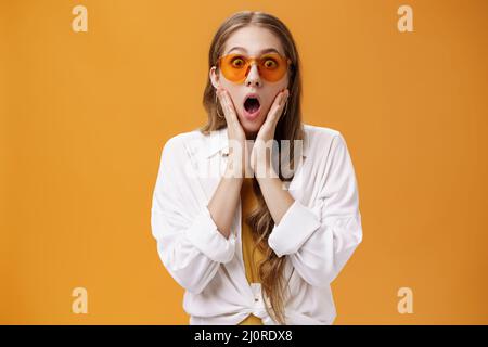 Photo à la taille de la jeune fille surprise et stupéfait dans des lunettes de soleil tendance et une tenue fraîche qui souffle de la position de choc avec la Mo ouverte Banque D'Images