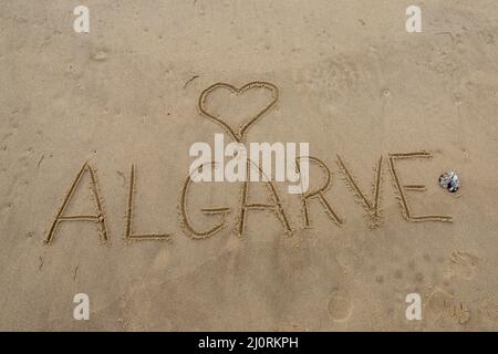 Mot Algarve écrit dans le sable avec un coeur Banque D'Images