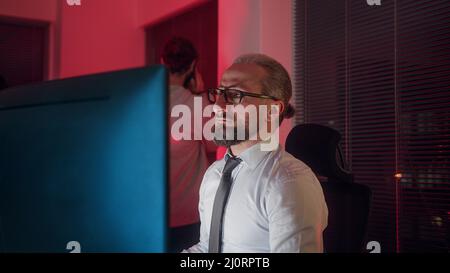Le chef de la direction ou le patron de l'entreprise d'âge moyen forme son stagiaire, en essayant d'aider l'employé avec un signal de main Banque D'Images