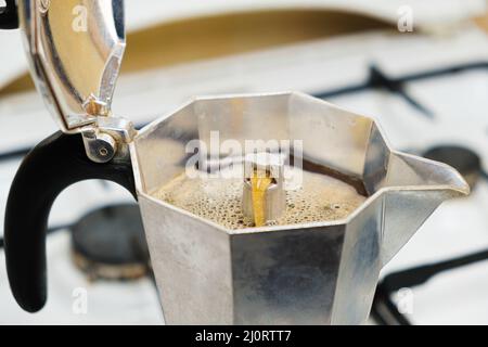 Café fraîchement préparé dans une cafetière geyser située sur une cuisinière à gaz Banque D'Images
