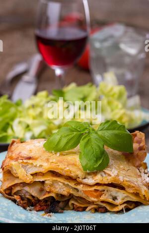 lasagnes avec salade sur bois sombre Banque D'Images