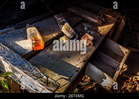 Bouteilles sur un banc dans un bâtiment abandonné Banque D'Images