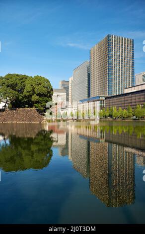 Gratte-ciels du quartier de Marunouchi reflétant dans l'eau de la lande extérieure du château d'Edo. Tokyo. Japon Banque D'Images