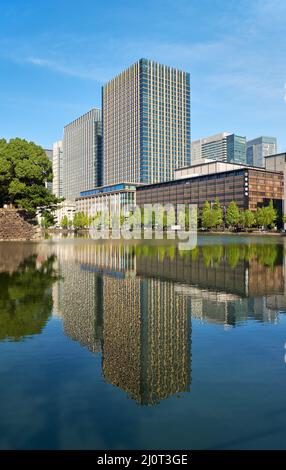 Gratte-ciels du quartier de Marunouchi reflétant dans l'eau de la lande extérieure du château d'Edo. Tokyo. Japon Banque D'Images