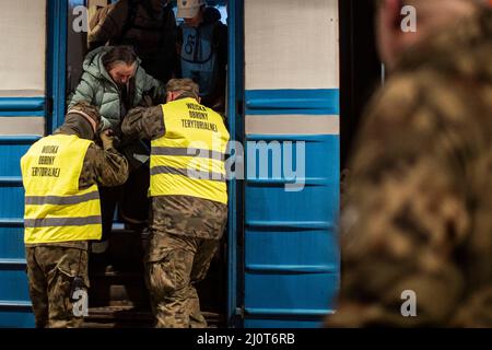 Przemysl, Pologne. 20th mars 2022. Les soldats aident une femme à partir d'un train qui est arrivé à la gare de Lviv, en Ukraine. Environ 1000 personnes étaient à bord du train pour fuir la guerre dans leur patrie. Credit: Christoph Reichwein/dpa/Alay Live News Banque D'Images