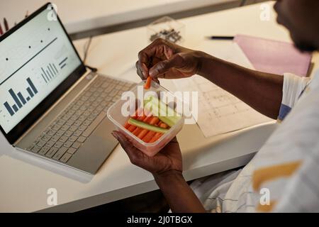 Gros plan de jeunes Afro-américains qui mangent des collations saines tout en travaillant ou en étudiant tard la nuit, espace de copie Banque D'Images