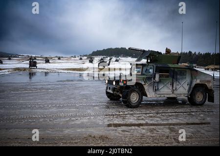 Soldats de la Compagnie Echo, 2nd Bataillon 227th Aviation Regiment, 1st brigade de cavalerie aérienne, garés à l'intérieur d'un véhicule à roues polyvalent de haute mobilité (HMMWV) le long d'un aérodrome avec des hélicoptères AH-64E Apache de la troupe Alpha, 7th Escadron 17th Cavalry Regiment, 1st brigade de cavalerie aérienne en préparation à l'exercice d'entraînement Allied Spirit, Centre de préparation multinational conjoint, Hohenfels, Allemagne. Banque D'Images