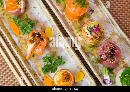Plateau décoré avec différentes saveurs de sushis élégants. Mise au point sélective. Banque D'Images