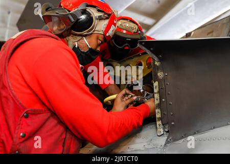 MER DES PHILIPPINES (janv 23, 2022) Aviation Ordnanceman Airman Marquise Goldsmith, à gauche, de Greenville, S.C., Et l'Ordnanceman de l'aviation 2nd classe Nigel Jacques, de San Antonio, affecté aux 'Chargerss' de l'escadron de combat de la mer d'hélicoptère (HSC) 14, effectue l'entretien d'un hélicoptère MH-60s Sea Hawk dans la baie hangar à bord du porte-avions USS de Nimitz Abraham Lincoln (CVN 72). Les groupes de grève des transporteurs Carl Vinson et Abraham Lincoln mènent des opérations de double transporteur afin de faire progresser l'interopérabilité de la Force conjointe tout en démontrant notre engagement envers une Indo-Pacific libre et ouverte. L'Indo-Pa des États-Unis Banque D'Images