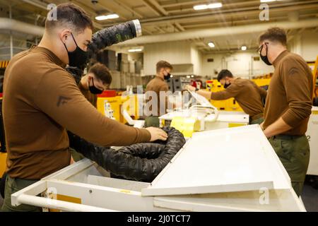 MER DES PHILIPPINES (janv 23, 2022) les Marines, affectés à l'escadron d'attaque des chasseurs de la Marine (VMFA) 314, effectuent des travaux d'entretien dans la baie hangar à bord du porte-avions USS Abraham Lincoln de la classe Nimitz (CVN 72). Les groupes de grève des transporteurs Carl Vinson et Abraham Lincoln mènent des opérations de double transporteur afin de faire progresser l'interopérabilité de la Force conjointe tout en démontrant notre engagement envers une Indo-Pacific libre et ouverte. La Force conjointe de commandement Indo-Pacifique des États-Unis cherche régulièrement des occasions d'agir en faveur de la paix et de la stabilité pour toutes les nations. (É.-U. Navy photo par Mass communication Specia Banque D'Images