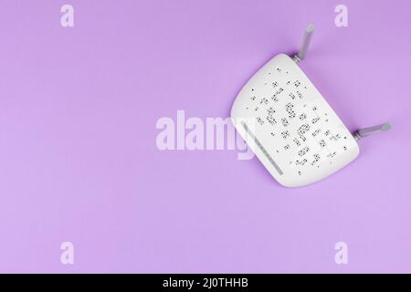 Nouveau routeur Wi-Fi blanc avec antennes grises sur fond violet clair vue du dessus à partir d'un espace de copie Banque D'Images