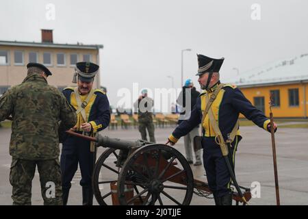 De gauche à droite, le colonel Marek Gmurski, ancien commandant de la zone d'entraînement de Drawsko Pomorskie, charge un canon avec un groupe de reenacteurs polonais après sa cérémonie de retraite à la zone d'entraînement du cours d'assaut tactique de Bucierz, Pologne, le 25 janvier 2022. La cérémonie a rendu hommage au colonel Marek Gmurski, qui a servi de commandant de la DPTA depuis 2010 et qui s'est fortement concentré sur l'interopérabilité entre les forces armées polonaises et d'autres forces de l'OTAN, y compris les troupes américaines, pour soutenir les opérations de l'OTAN. (É.-U. Photo de l'armée par le Sgt. Tara Fajardo Arteaga) Banque D'Images