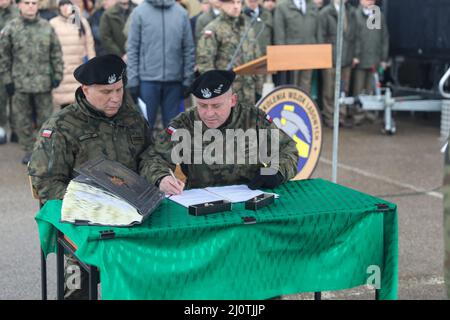 De gauche le colonel Marek Gmurski, commandant sortant de la zone d'entraînement de Drawsko Pomorskie (DPTA) regarde le lieutenant-colonel Andrzej Negmanski signer officiellement un document pour recevoir le poste de commandement à la DPTA lors d'une cérémonie de changement de commandement à la zone d'entraînement de Bucierz Tactical Assault, Pologne, le 25 janvier 2022. La cérémonie de passation de commandement a eu lieu conjointement avec la cérémonie de retraite du colonel Marek après 40 ans de service dans les forces armées polonaises. (É.-U. Photo de l'armée par le Sgt. Tara Fajardo Arteaga) Banque D'Images