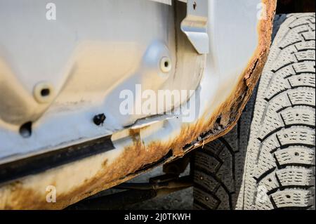 Partie rouillée de la carrosserie avec corrosion par corrosion. Contexte pour les voitures nécessitant une réparation de carrosserie Banque D'Images