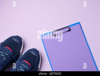 Paire de sneakers en tissu bleu sur fond violet, vue du dessus Banque D'Images