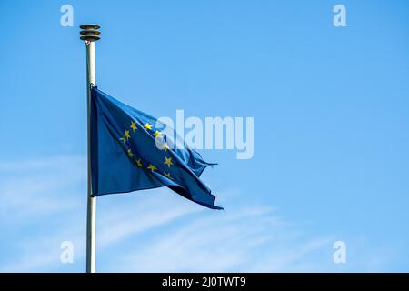 Drapeau de l'UE usé contre un ciel bleu, pas de nuages Banque D'Images