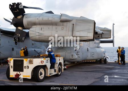 Les marins de la Marine américaine à bord du navire d'assaut amphibie USS America (LHA 6) tractent un appareil MV-22B Osprey Tiltrotor avec le Marine Medium Tiltrotor Squadron 265 (renforcé), 31st Marine Expeditionary Unit (MEU), pour le préparer à une opération de livraison aérienne, en mer des Philippines, le 28 janvier 2022.La livraison des fournitures essentielles de la mission par hydroglisseur permet de maintenir les opérations sur le terrain, ce qui permet aux Marines de rester plus longtemps dans le combat.Le MEU 31st opère à bord de navires de l'Amérique Amphiobie Ready Group dans la zone d'opérations de la flotte 7th pour améliorer l'interopérabilité avec les alliés et les partenaires et servir de réponse prête à l'emploi Banque D'Images