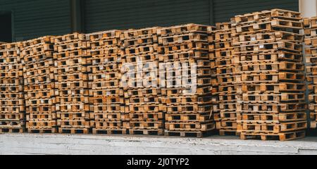 Piles de palettes en bois dans un entrepôt extérieur pour le transport industriel. Banque D'Images