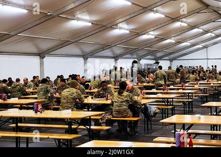 Mielec, Pologne. 12th mars 2022. Les soldats dînent dans une tente de Mielec, en Pologne. Grâce à son programme d'augmentation civile logistique, la Brigade de soutien sur le terrain de l'armée de 405th a établi des opérations de soutien à la vie pour des milliers de soldats américains déployés en Europe. Les endroits où LOGCAP fournit des chambres, des douches, des latrines, des restaurants et plus encore incluent Mielec et ZamoÅ‡ en Pologne, Mihail Kogalniceanu en Roumanie, Wiesbaden et Ansbach en Allemagne, et Zutendaal et Brunssum en Belgique. Crédit: Armée américaine/ZUMA Press Wire Service/ZUMAPRESS.com/Alamy Live News Banque D'Images