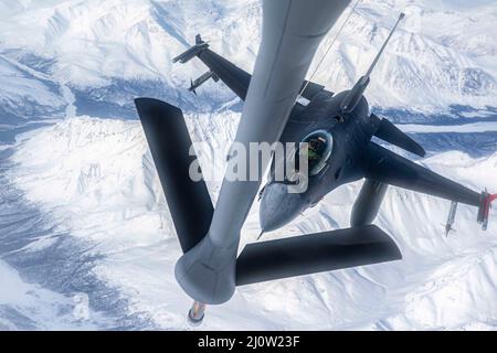 Le 16 mars 2022 - base interarmées Elmendorf-Richardson, Alaska, États-Unis - Un faucon de combat F-16 de la Force aérienne des États-Unis, affecté à la 180th Escadre Fighter, arrive pour ravitailler d'un escadron de ravitaillement aérien KC-135 Stratotanker 93rd lors d'une mission Arctic EDGE 2022 de l'exercice du Commandement du Nord des États-Unis, le 16 mars 2022. AE22 est un exercice biennal de défense de la patrie conçu pour fournir une formation conjointe de haute qualité et efficace dans des conditions austères par temps froid. Le F-16 est un avion de chasse multirôle compact, extrêmement maniable et puissant pour les États-Unis. (Credit image: © U.S. Air Force/ZUMA Press Wire Servic Banque D'Images