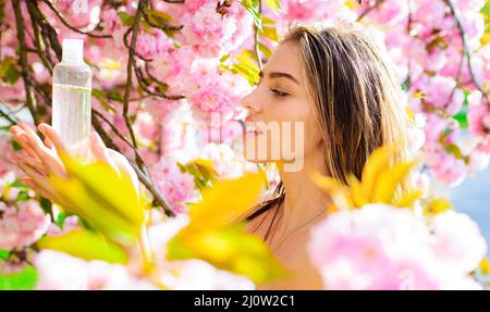 Nettoyant de maquillage pour la peau du visage. Femme avec bouteille d'eau micellaire. Soin de la peau. Traitement de l'acné Banque D'Images