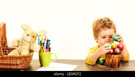 Chasse aux œufs. Enfant garçon dans des oreilles de lapin avec des œufs peints. Petit enfant mignon se préparer pour les vacances de Pâques. Banque D'Images