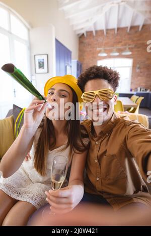 Un homme heureux qui prend le selfie avec sa petite amie qui fait la fête à la maison Banque D'Images