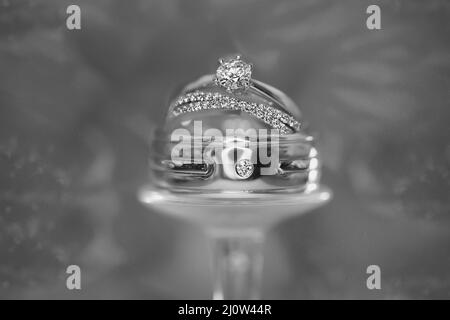 Anneaux de mariage empilés sur un verre retourné. Avec une image monotone. Banque D'Images