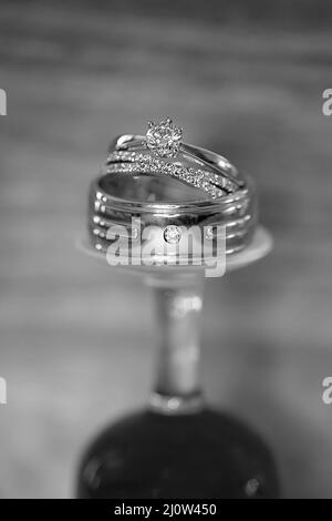 Les anneaux de mariage empilés sur un verre renversé Banque D'Images