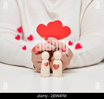 Paire d'hommes en bois de la mariée et du marié, cœur rouge, concept d'amour et de relations Banque D'Images